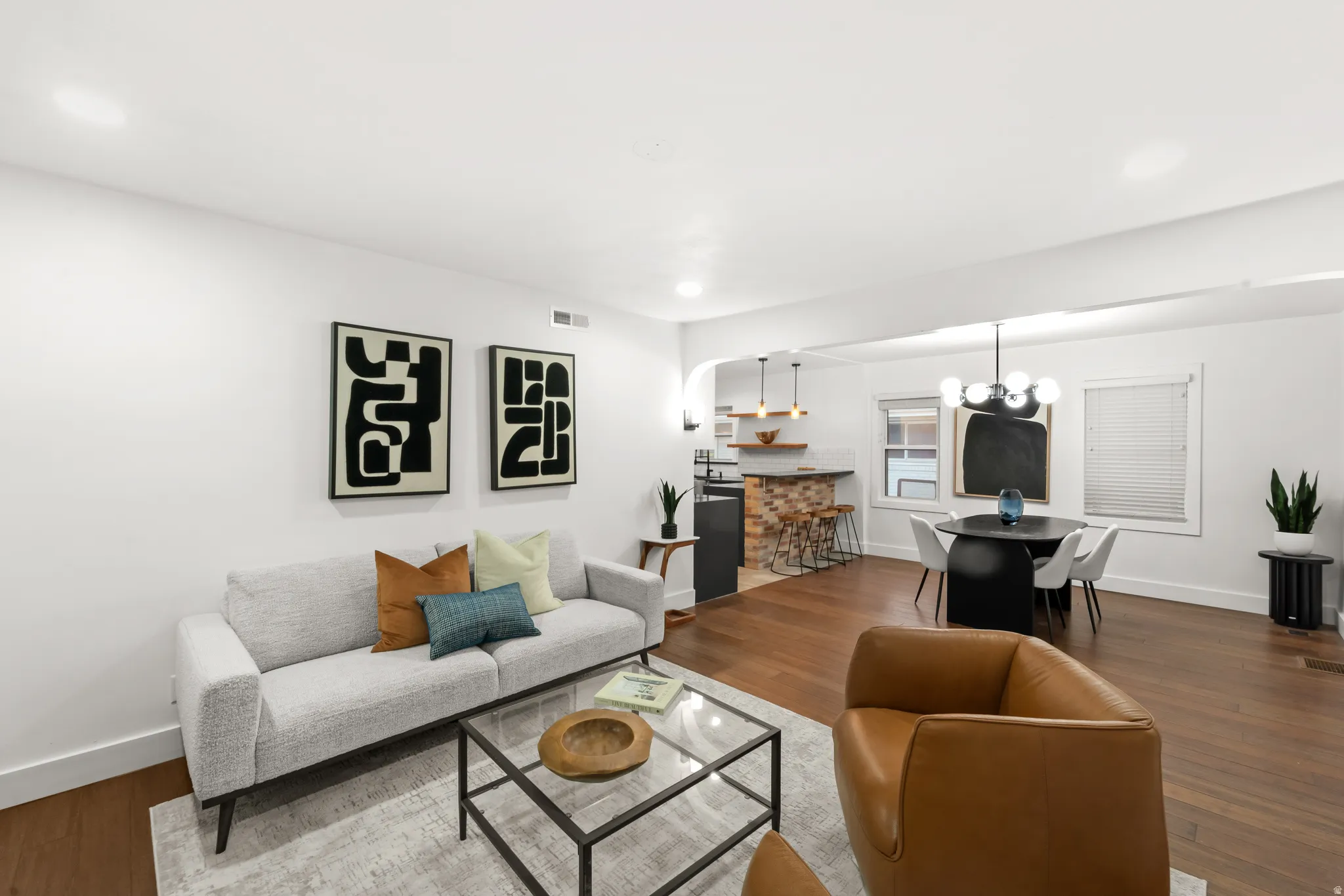 Expansive living area featuring wide-plank wood-finish flooring and recessed lighting