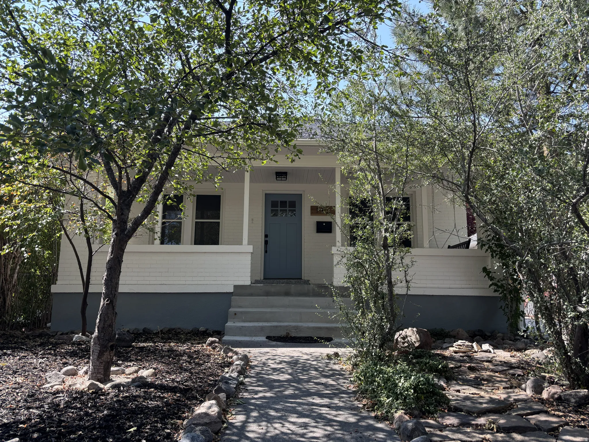 White exterior with a light blue entry door
