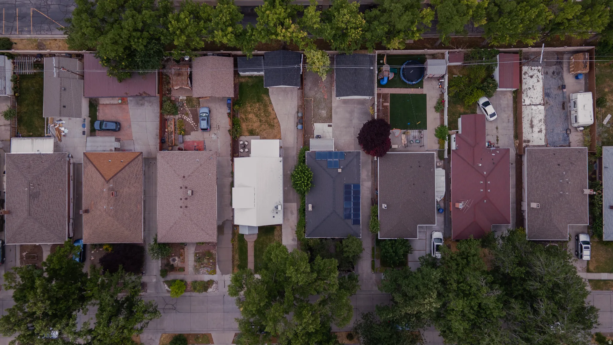 Aerial perspective showcasing multiple properties with varied rooflines and rear yard configurations