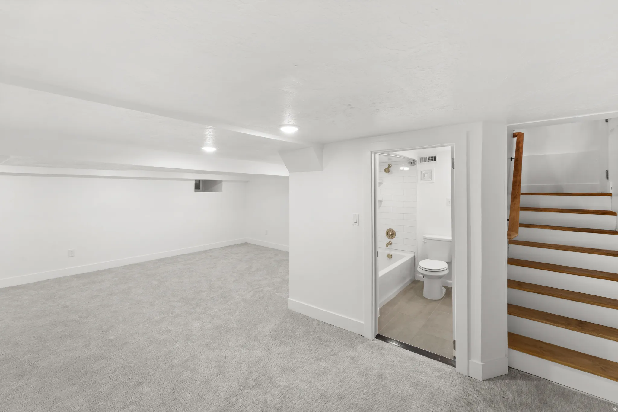 Finished room featuring light gray carpeting, white walls, and recessed lighting