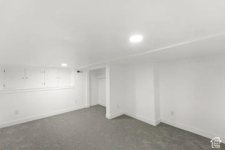 Carpeted interior space featuring white walls and recessed lighting