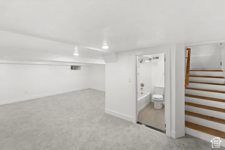 Finished room featuring light gray carpeting, white walls, and recessed lighting