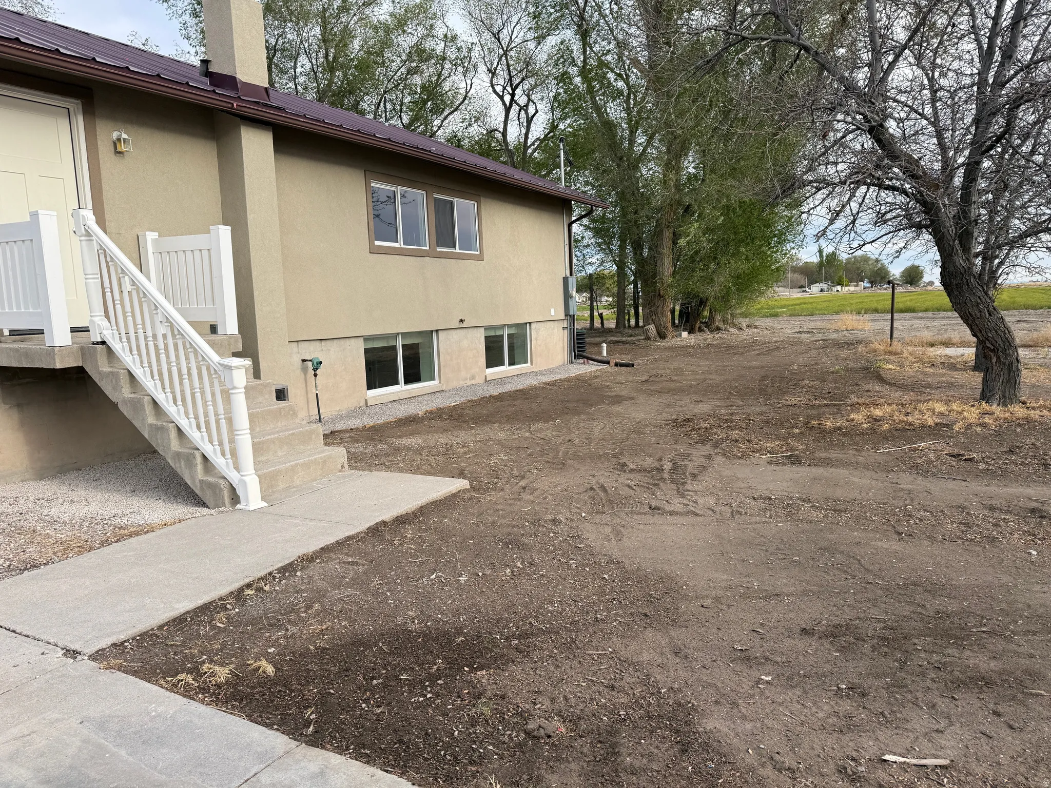 Stucco exterior with a brown metal roof