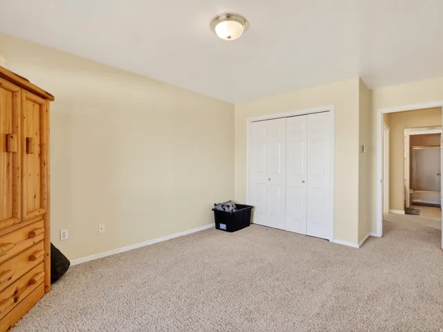 Soft beige carpeting extends throughout this room, complemented by neutral wall tones