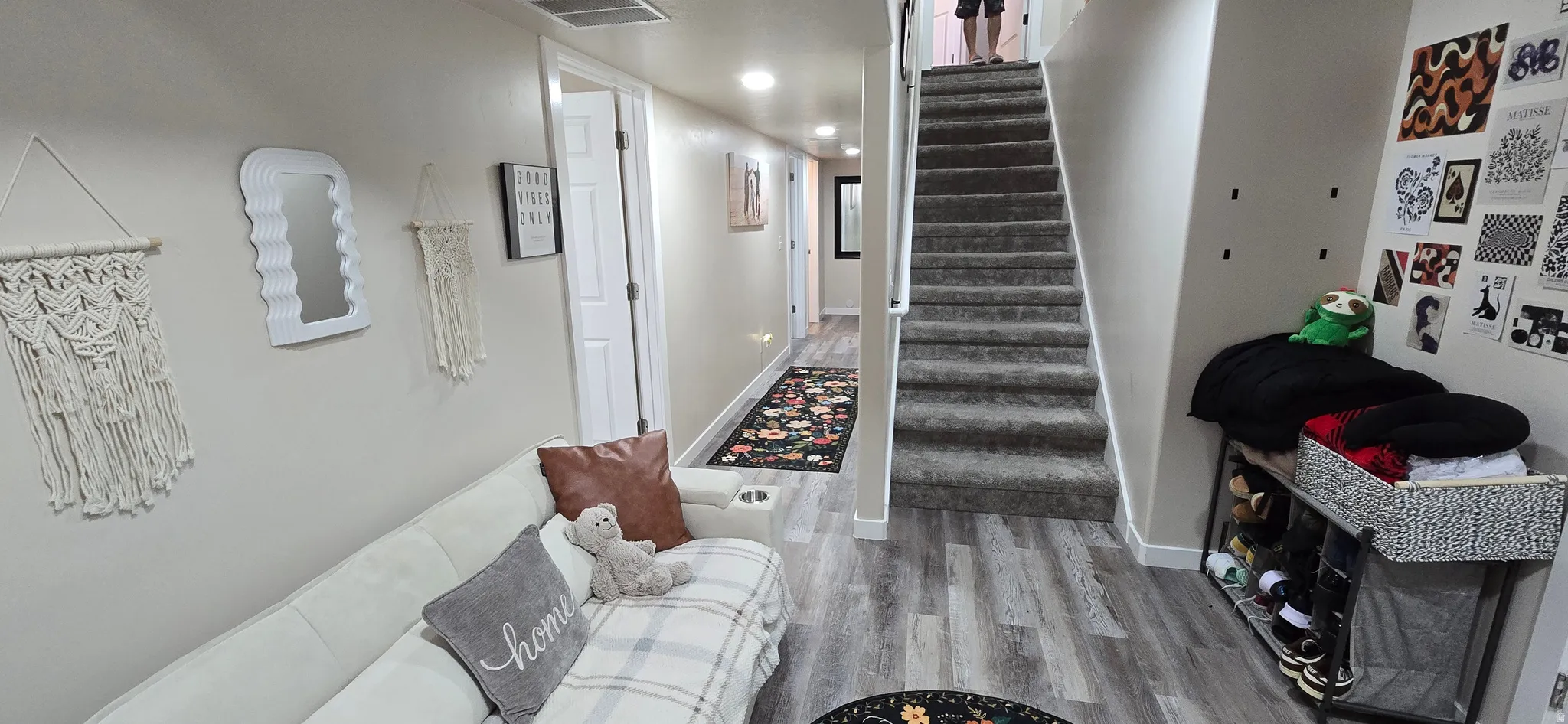 Finished lower level featuring wood-finish flooring, a carpeted staircase, recessed lighting, a hallway, and white interior doors