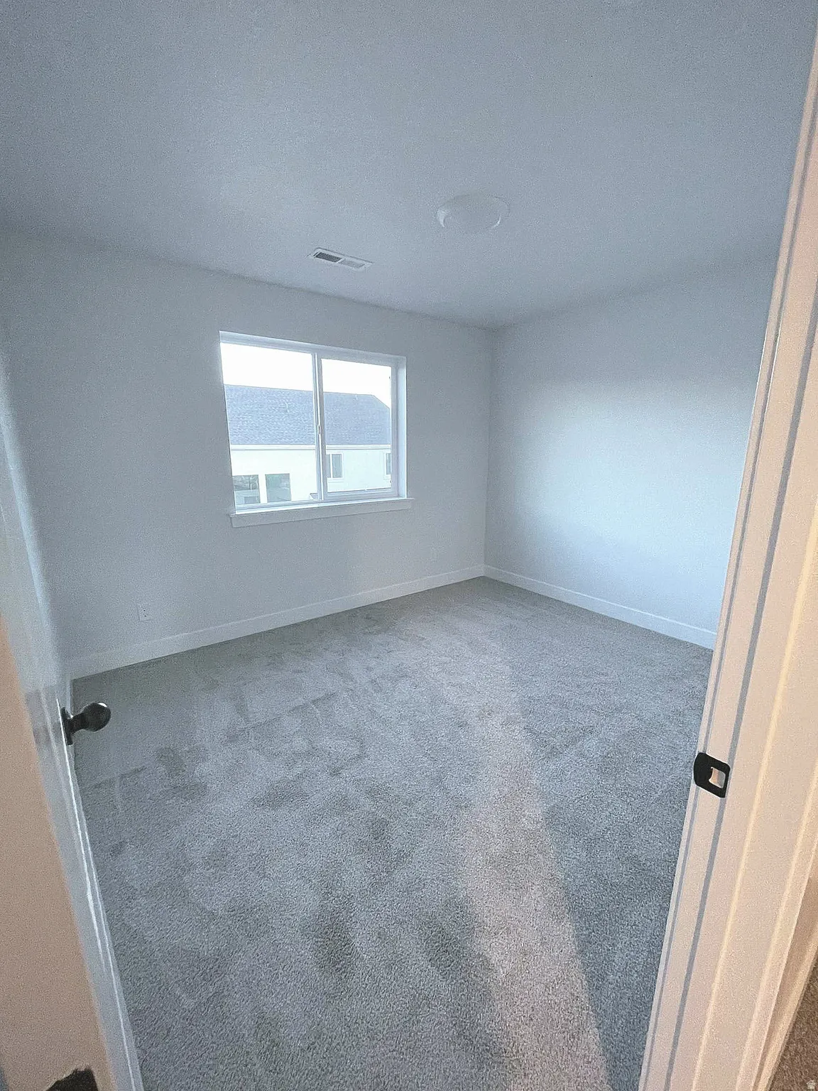 Room featuring light gray carpet, white walls, and a white ceiling with a flush-mount light fixture