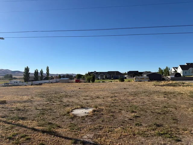 Expansive dry grass lot with distant mountain backdrop