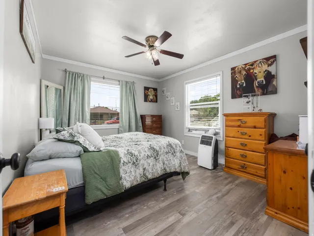 Spacious room featuring wood-finish flooring, light grey walls, and white trim