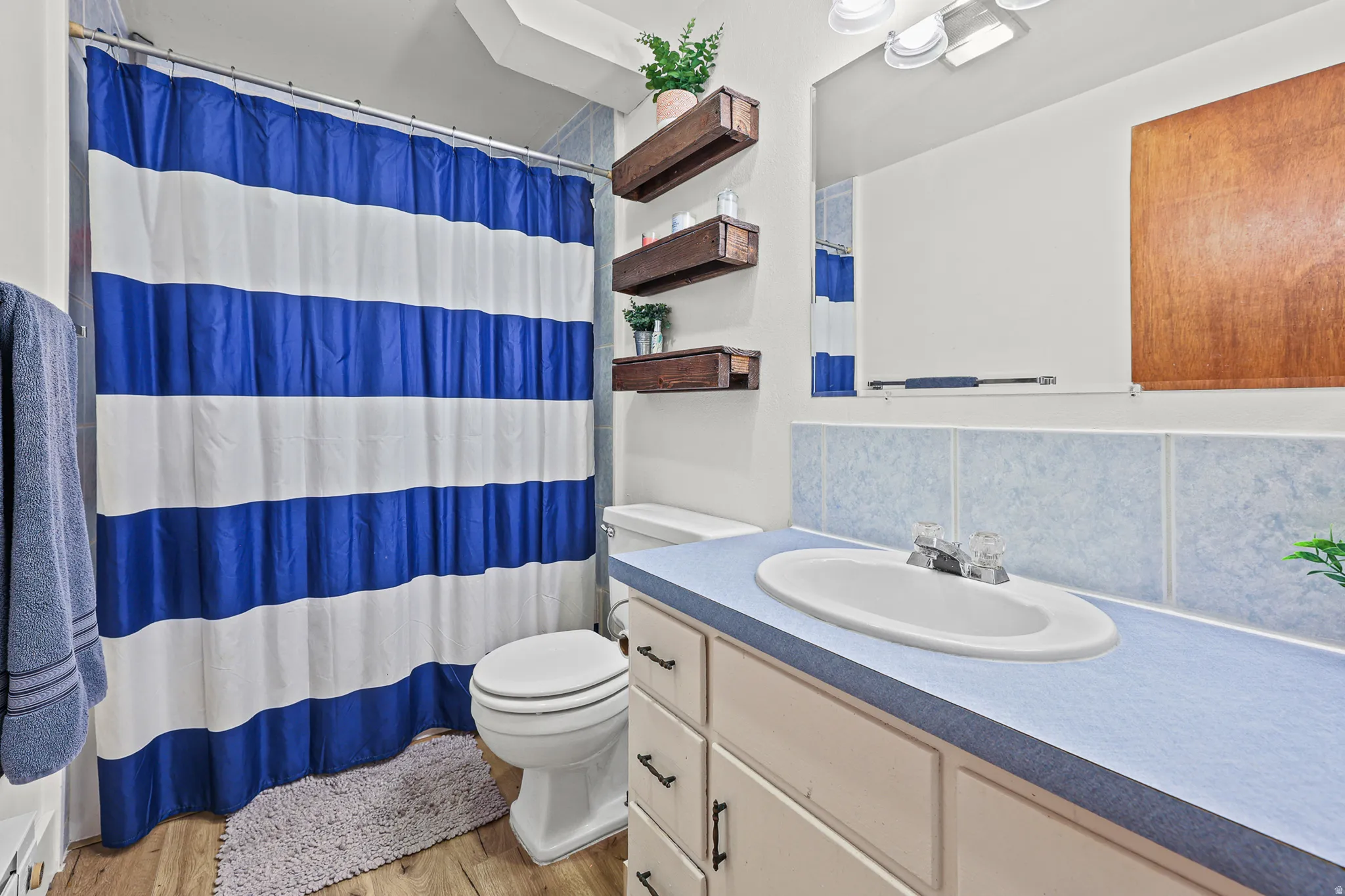 Bathroom featuring a single vanity with an oval sink and a blue countertop