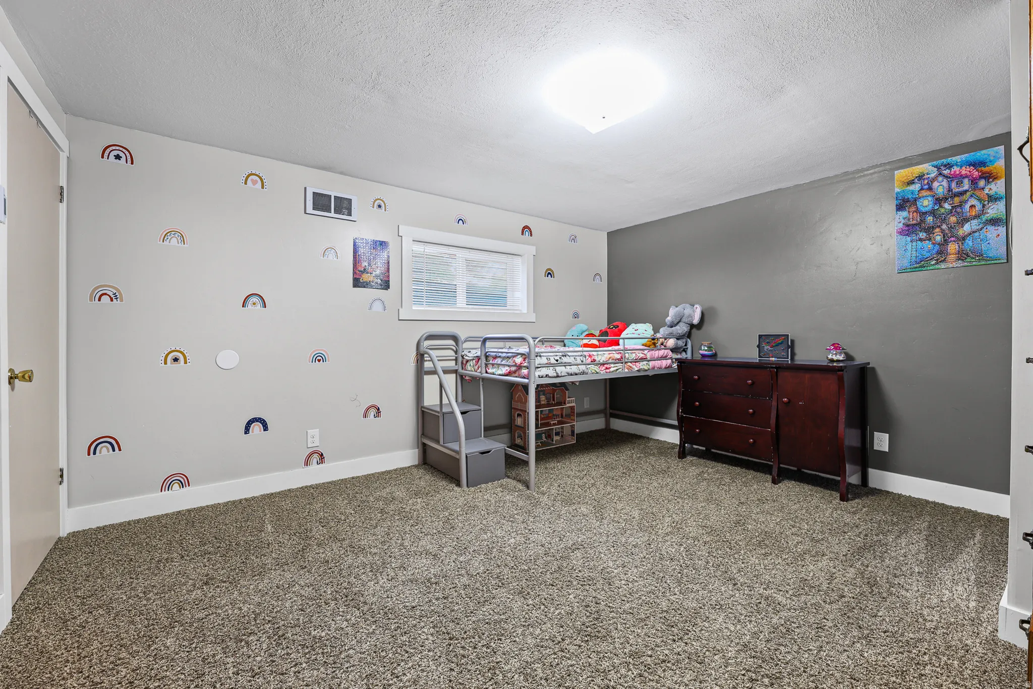 Spacious carpeted room with a ceiling-mounted light fixture
