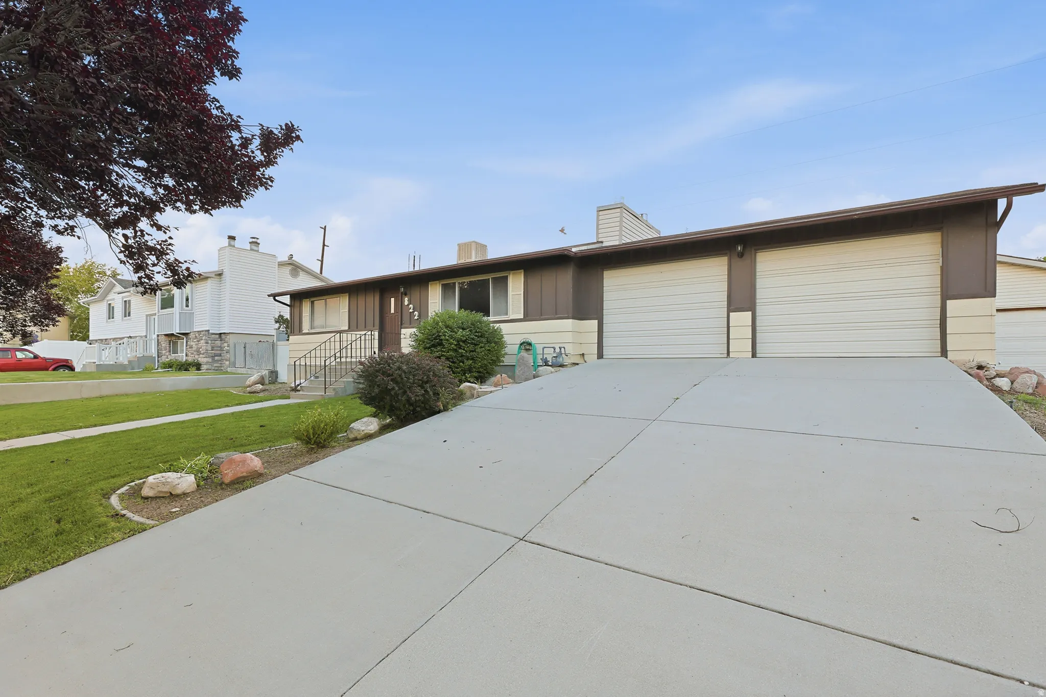 Ranch-style exterior with a dual garage featuring two white garage doors