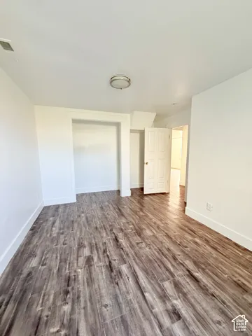 Room featuring wood-finish flooring, white baseboards, and a neutral color palette