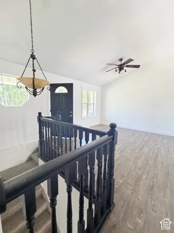 Split-level entry featuring dark wood-finish staircase railing and carpeted stairs