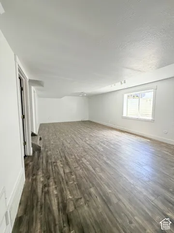 Spacious interior featuring wood-finish flooring, white walls, and a recessed window