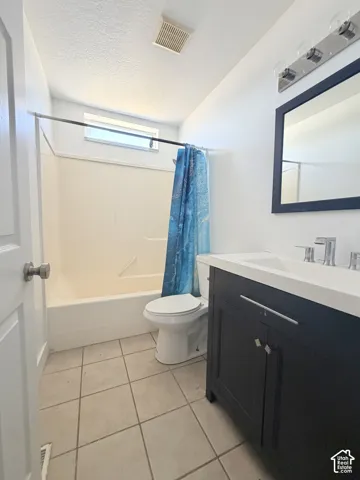 Bathroom featuring a dark wood vanity with a white countertop, chrome fixtures, and a framed mirror
