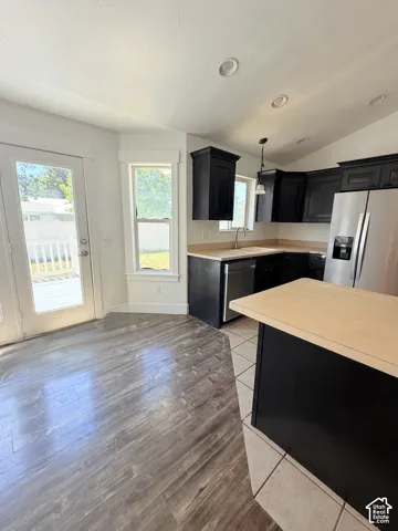 Kitchen featuring dark cabinetry, stainless steel appliances, and light wood-finish countertops