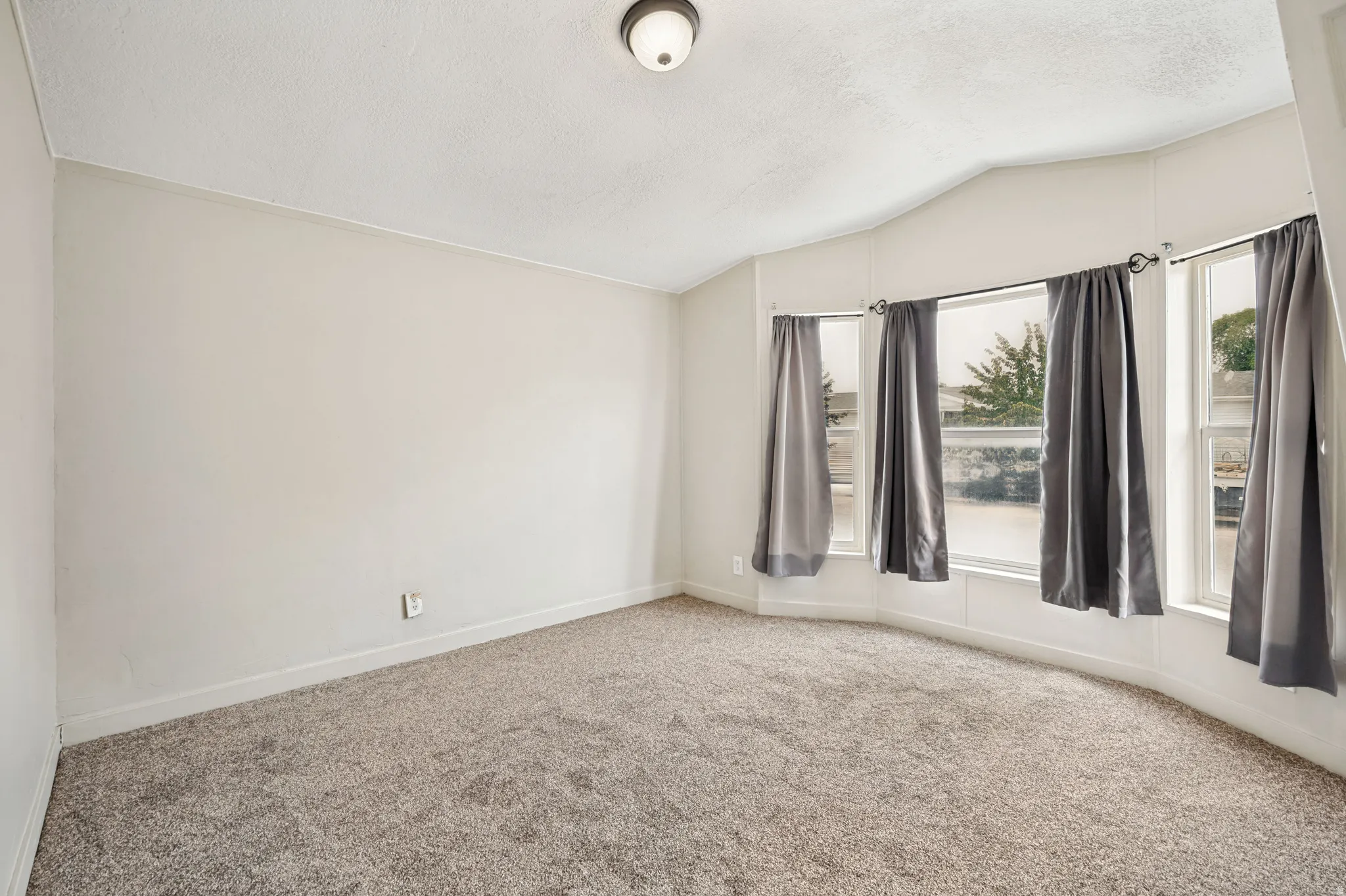 Spacious room featuring neutral carpeting and light-toned walls