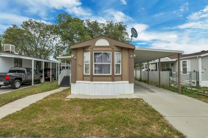 Single-story residence featuring a bay window, concrete driveway, and covered carport