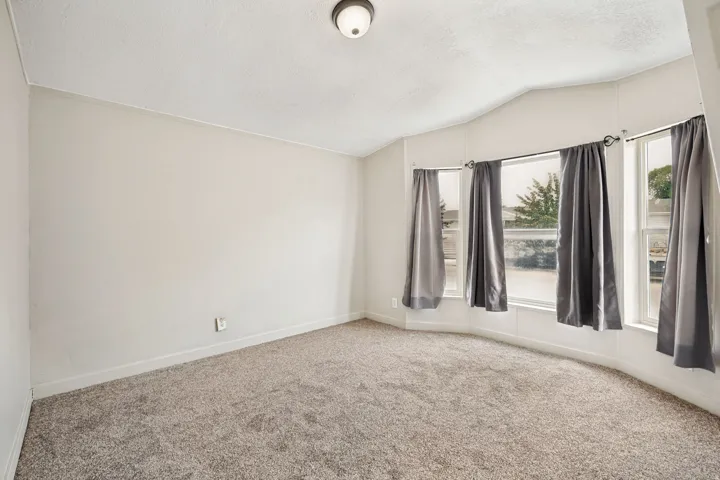 Spacious room featuring neutral carpeting and light-toned walls