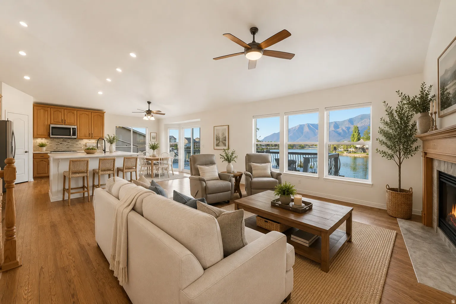 Open-concept living space featuring wood-finish flooring, recessed lighting, and a ceiling fan. AI Staged