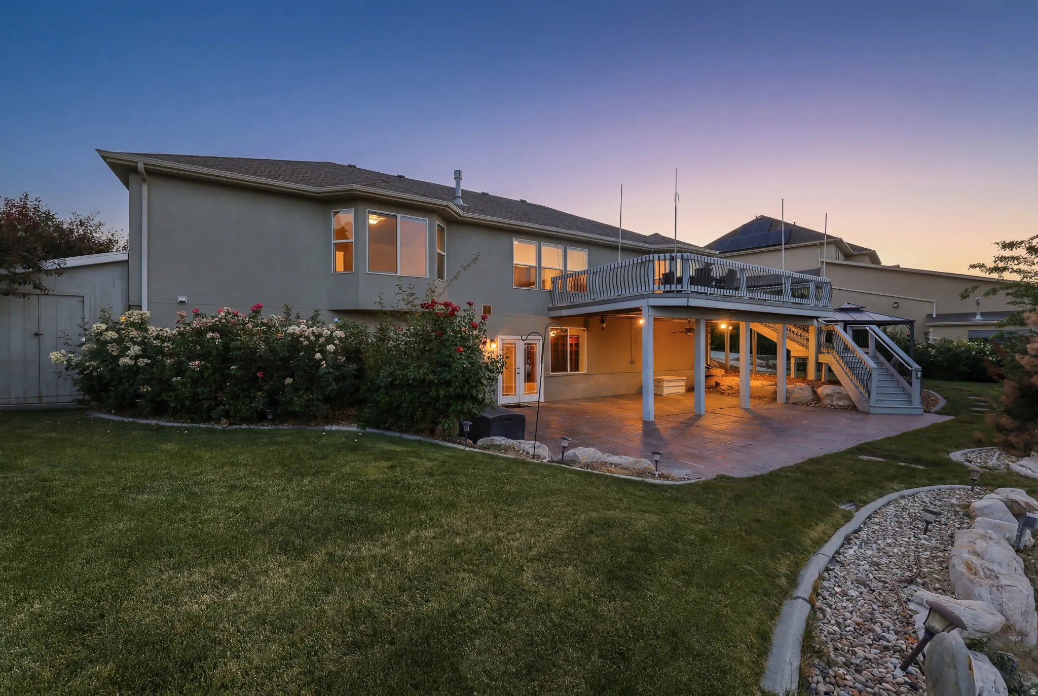 Multi-level exterior featuring a ground-level patio and an elevated deck with stairs