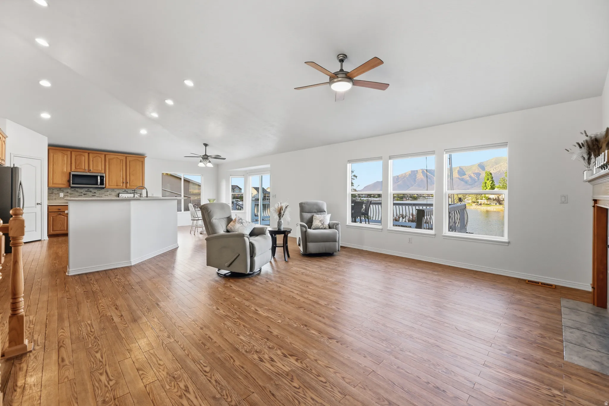 Open-concept living area featuring wood-finish flooring, recessed lighting, and vaulted ceilings