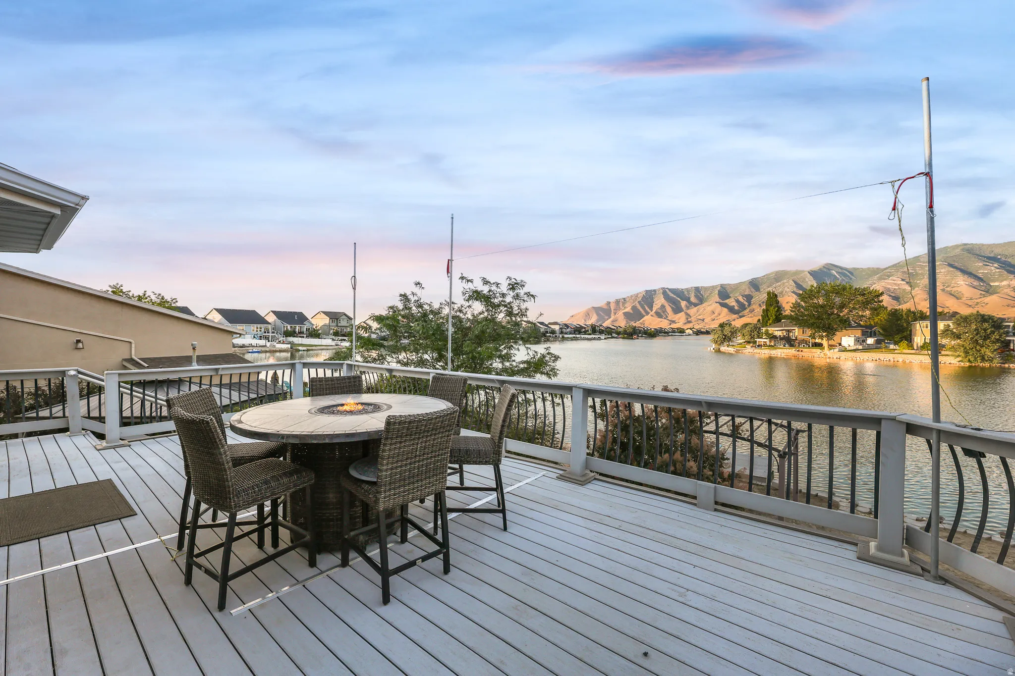 Spacious outdoor deck with composite decking, black metal railings, and a fire pit table