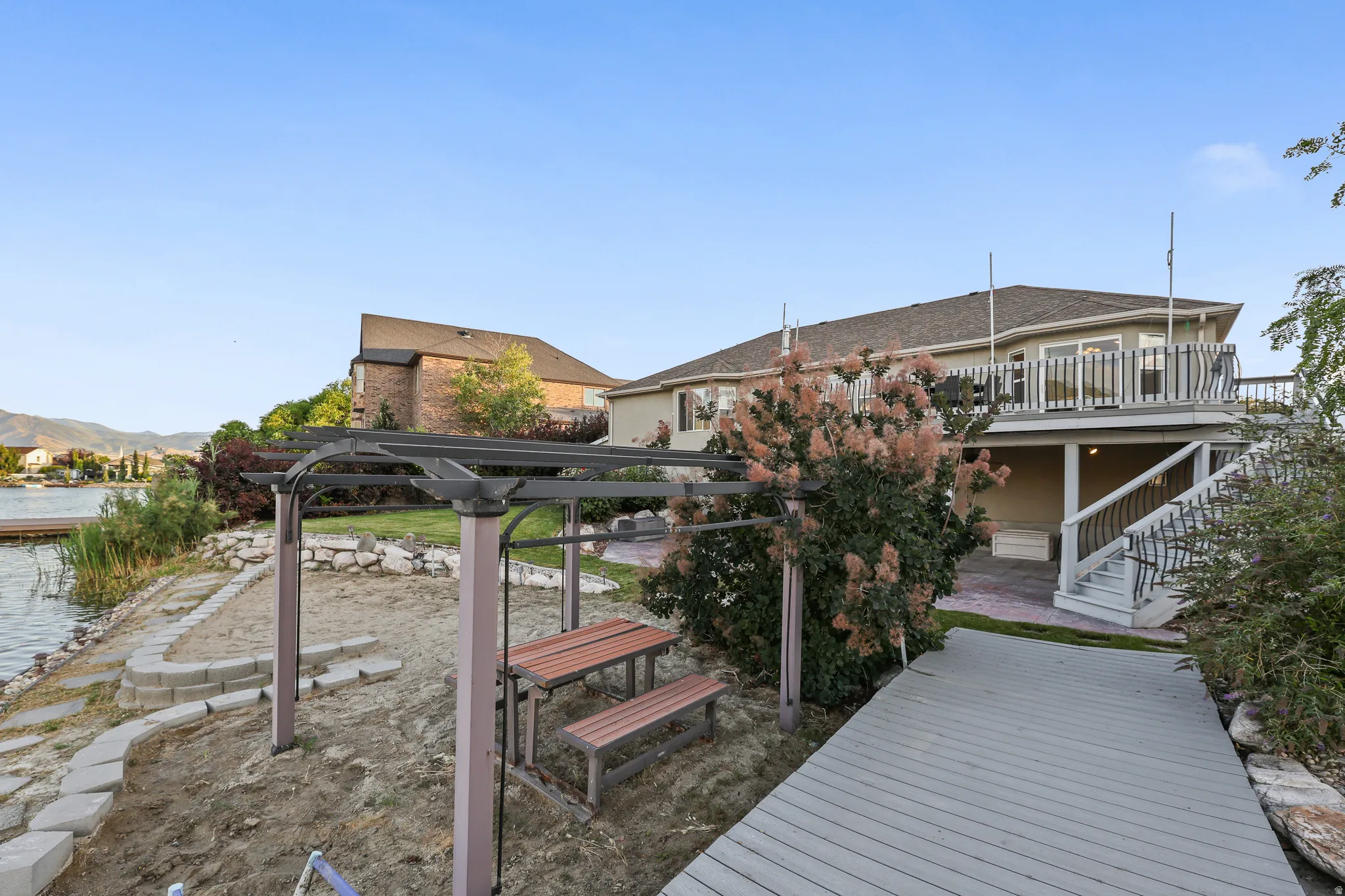 Lakefront property featuring a private dock, multi-level deck, and a stone-lined seawall