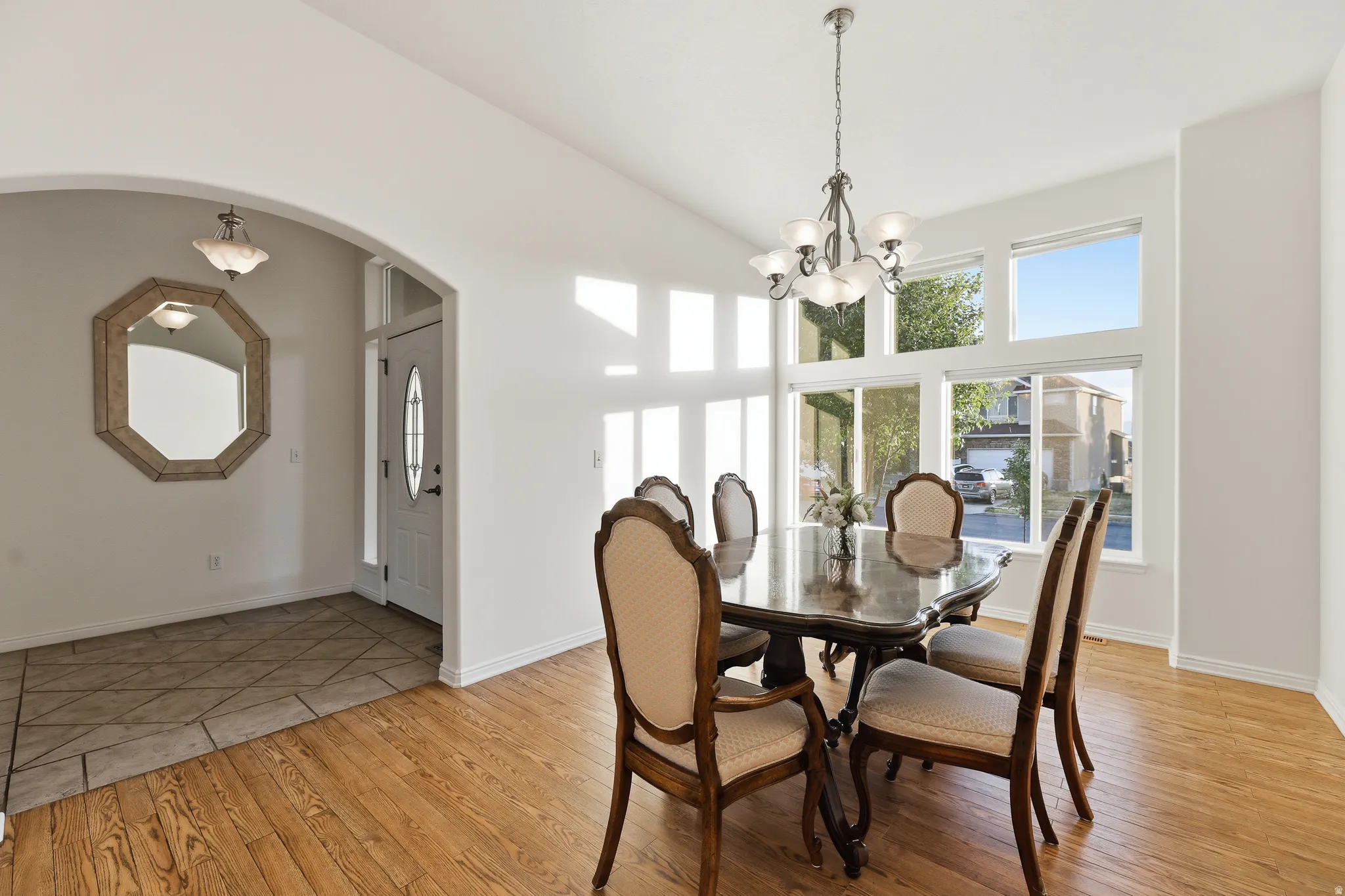Dining area featuring vaulted ceilings, large windows, and wood-finish flooring