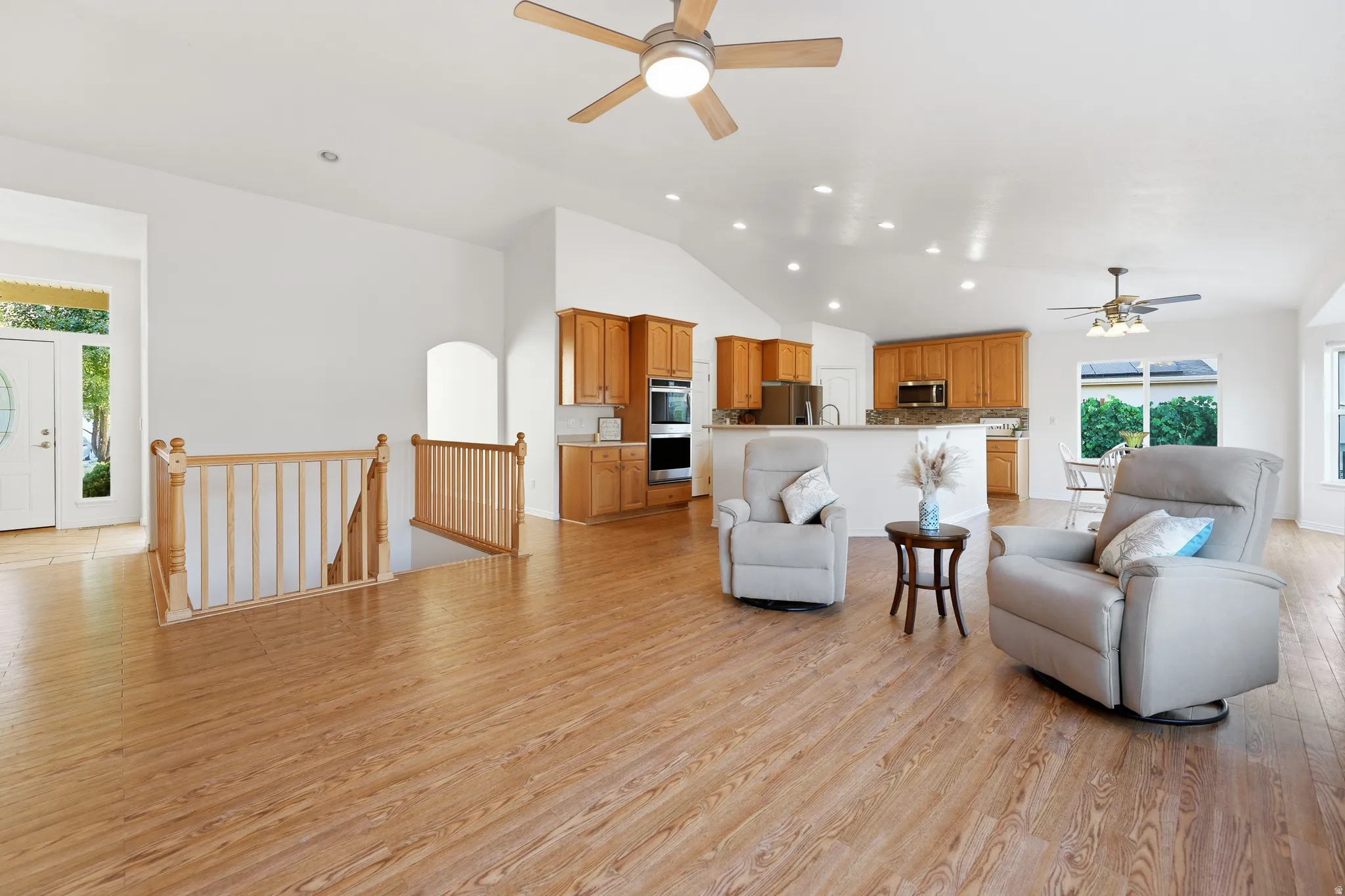 Spacious interior featuring wood-finish flooring, vaulted ceilings, and recessed lighting