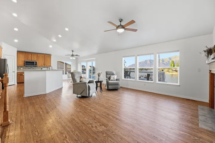 Open-concept living area featuring wood-finish flooring, recessed lighting, and vaulted ceilings
