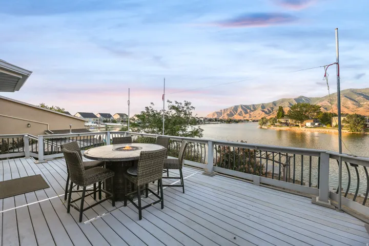 Spacious outdoor deck with composite decking, black metal railings, and a fire pit table