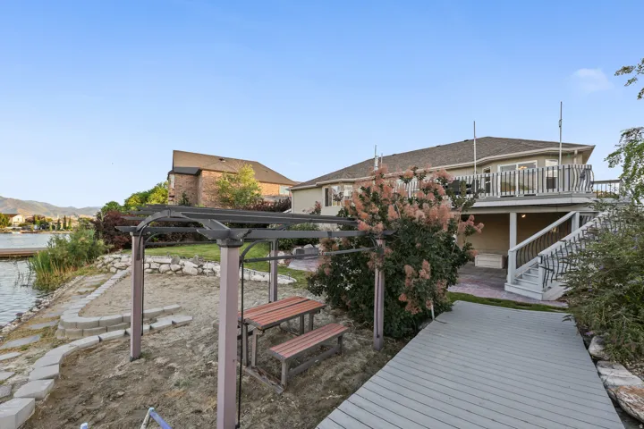 Lakefront property featuring a private dock, multi-level deck, and a stone-lined seawall