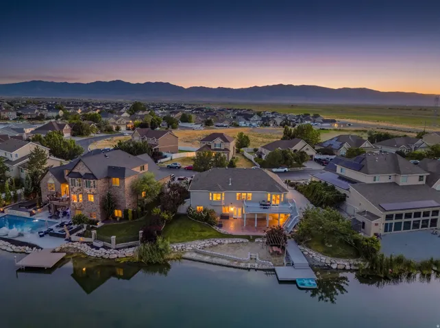 Waterfront property featuring a private dock, an expansive patio, and an in-ground swimming pool