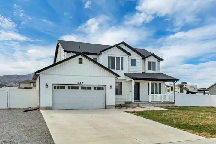 Two-story white siding residence featuring a two-car garage with a panel window design