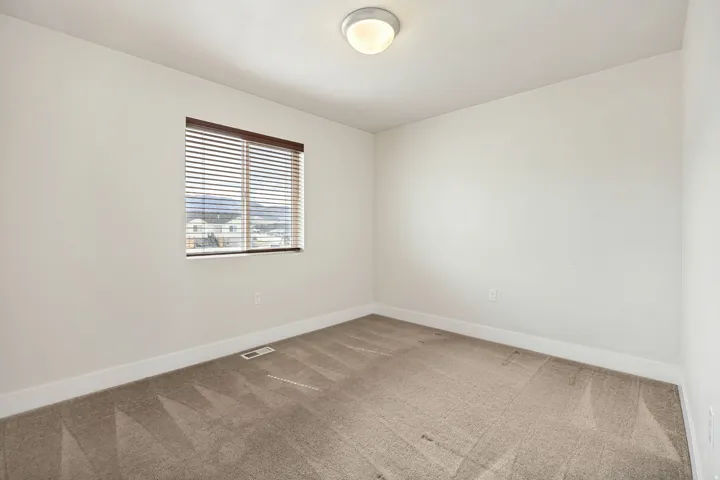 Neutral wall finishes with a window featuring horizontal blinds