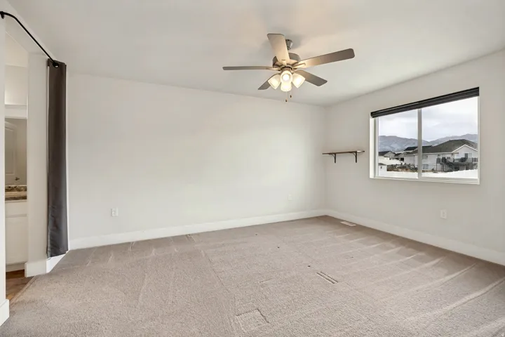 Spacious room featuring neutral carpeting and white walls