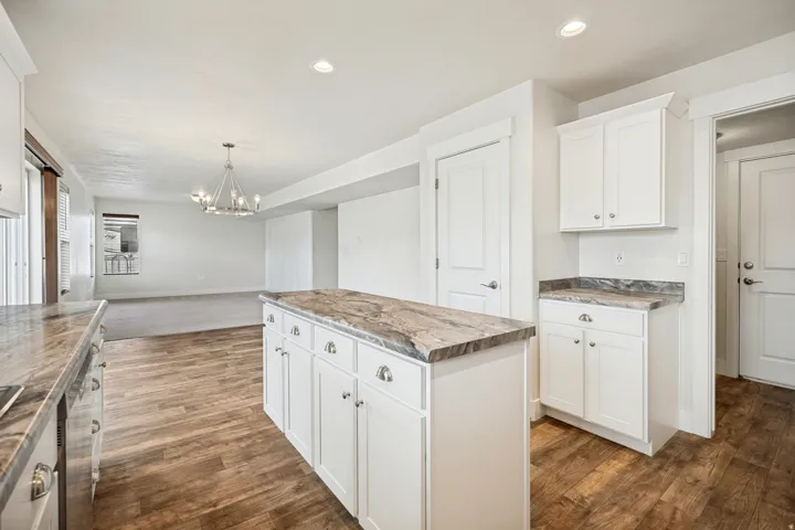 Kitchen island with white cabinetry and a patterned countertop