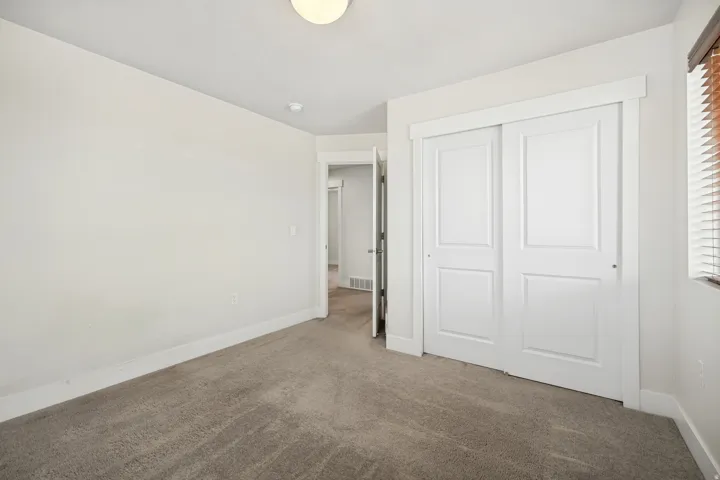 Spacious room featuring neutral carpeting and light-colored walls