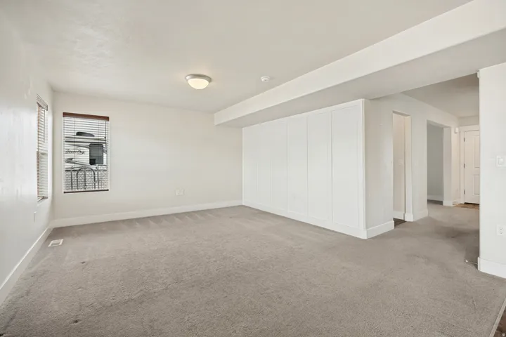 Spacious interior room with light grey carpeting