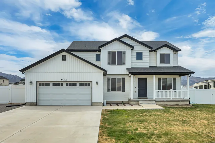 Two-story residence featuring white siding and dark trim