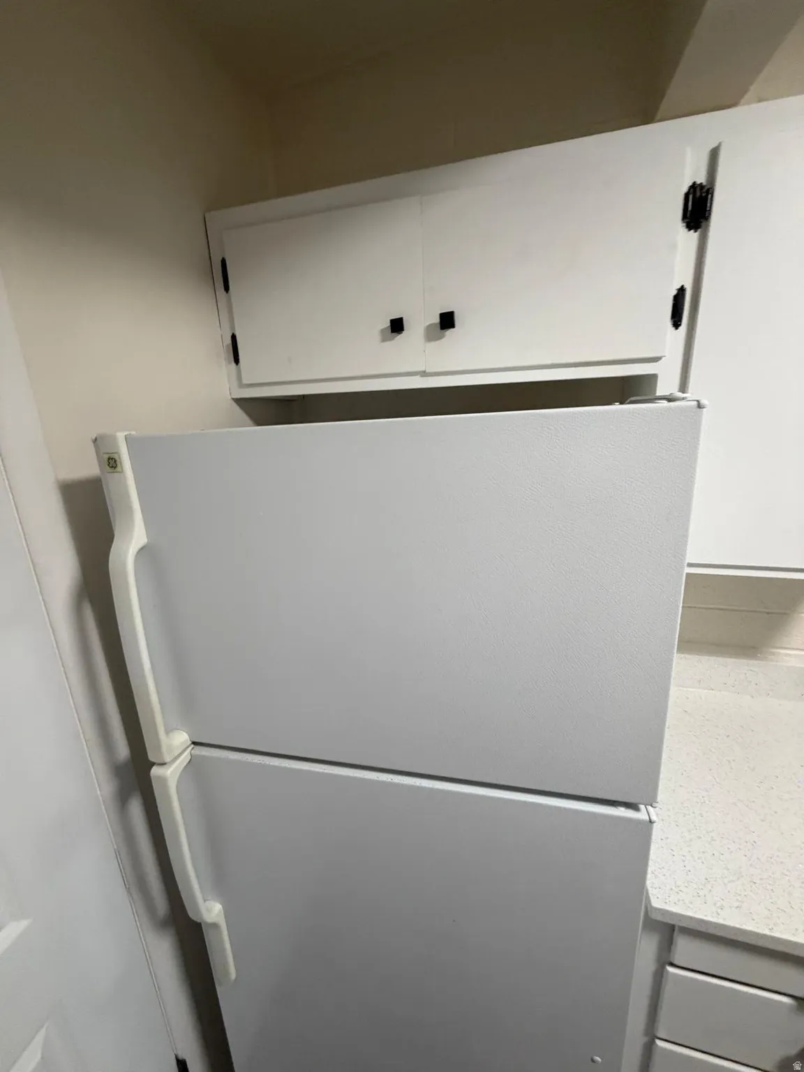 White overhead cabinetry with dark square pulls