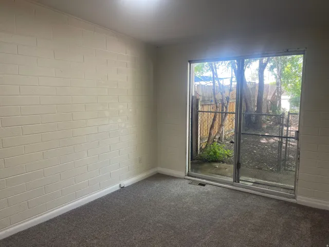 Sliding glass door opening to an outdoor area with mature trees