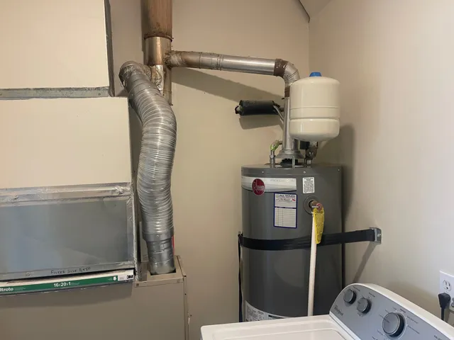 Utility area featuring a water heater, expansion tank, HVAC system, and electrical outlet