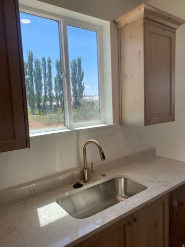 Single basin stainless steel sink with a gold-tone gooseneck faucet