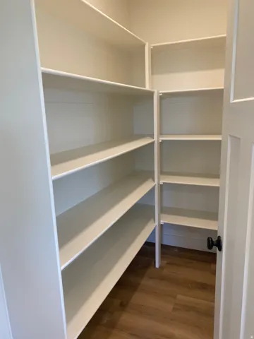 Walk-in pantry featuring extensive white shelving