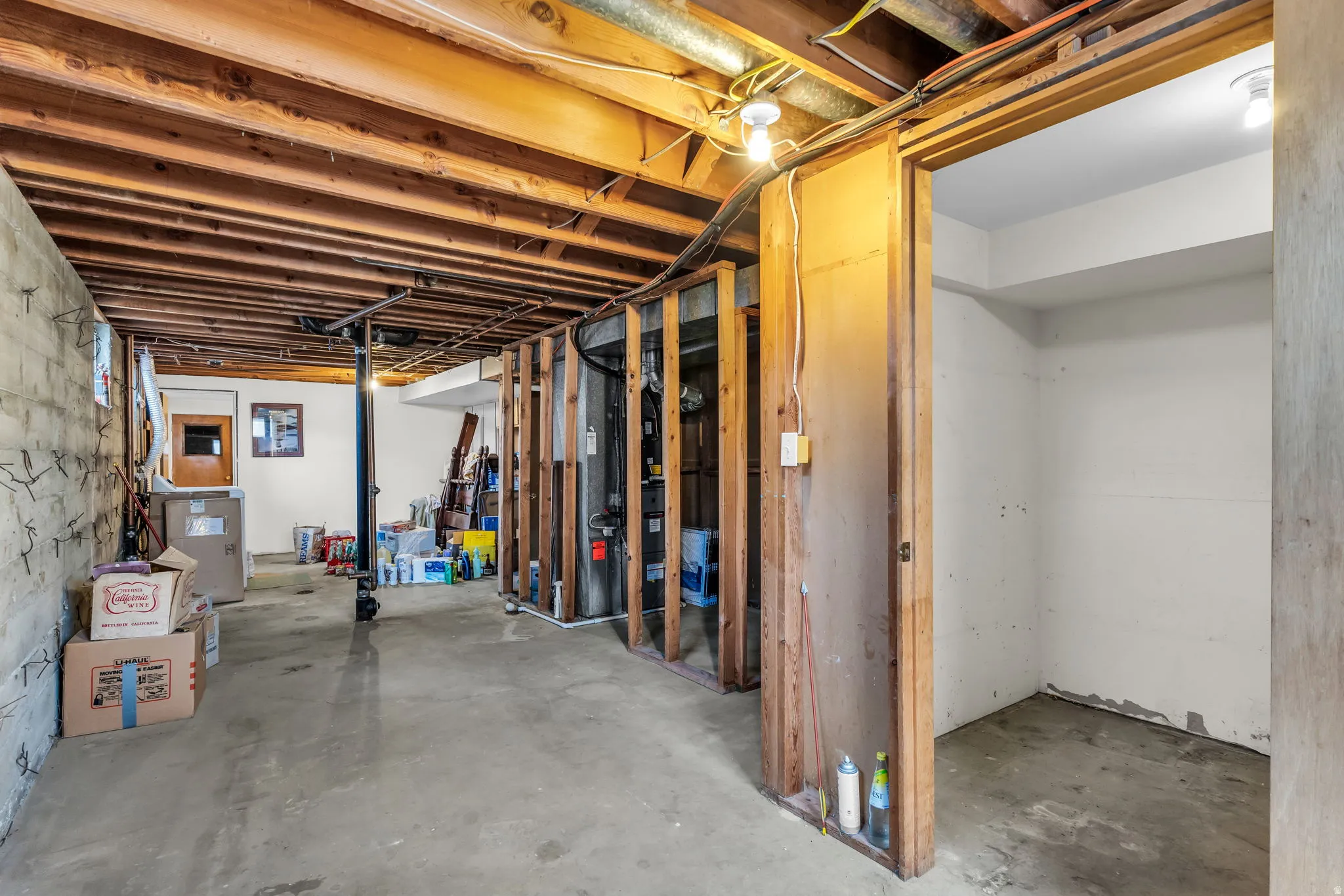 Exposed ceiling joists and concrete flooring provide a foundational space