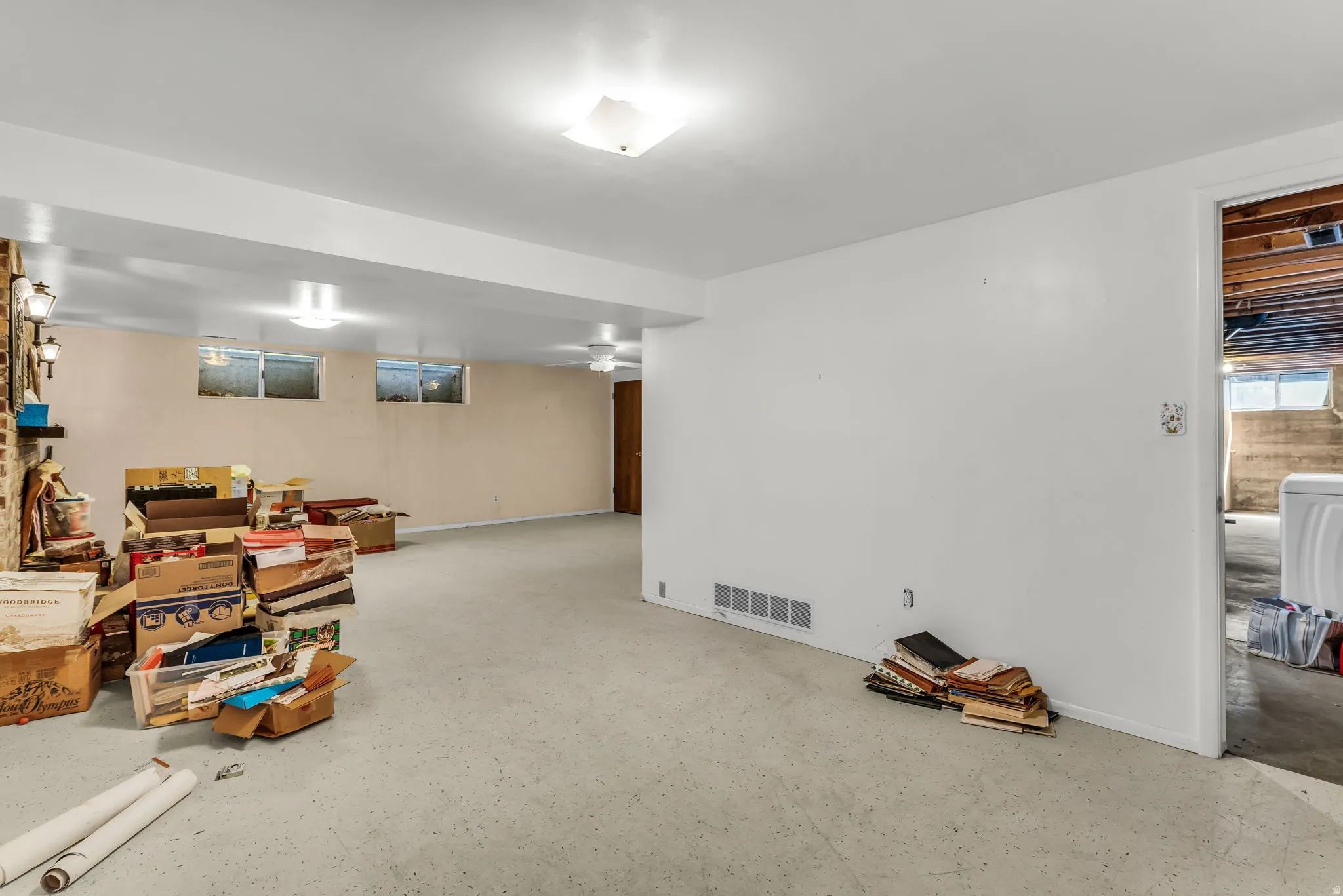 Spacious lower level offering a large open area, recessed lighting, and a partial brick wall accent