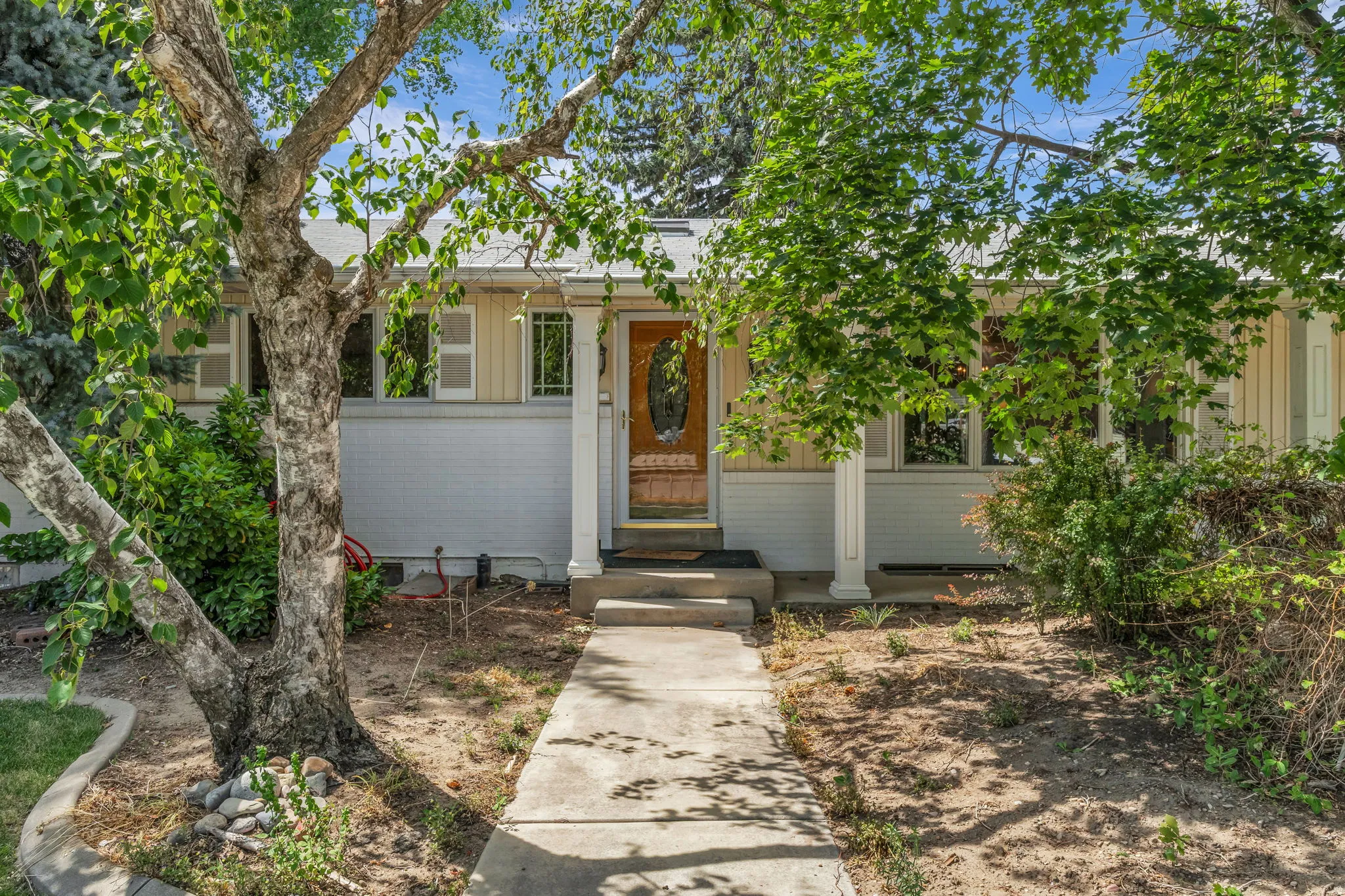 Mid-century modern exterior featuring a light-colored brick facade and contrasting vertical siding