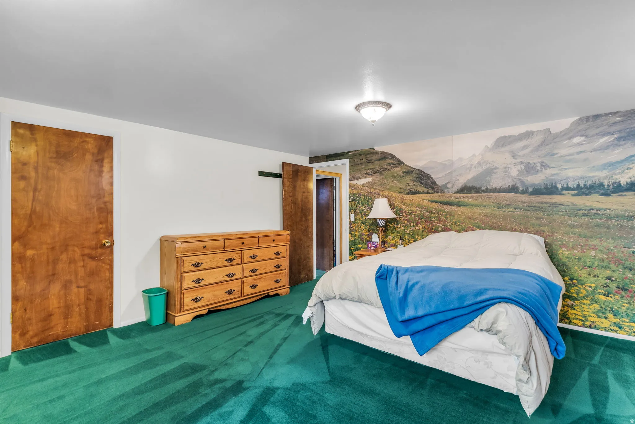 Bedroom featuring a full-wall mural, overhead flush-mount lighting, and solid wood interior doors